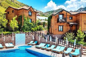 a pool with lounge chairs and a house at Nebesa Hotel EZ in Chimgan