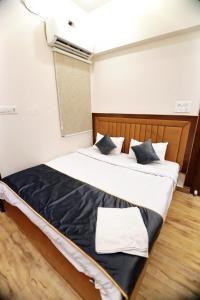 a bedroom with a large bed with black and white pillows at Bless Inn in Prayagraj +5 photos