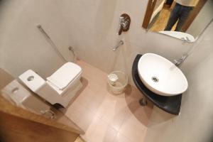 a bathroom with a sink and a toilet and a mirror at Bless Inn in Prayagraj