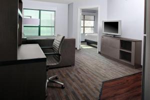 a hotel room with a bed and a desk with a television at Hyatt House Dallas Uptown in Dallas