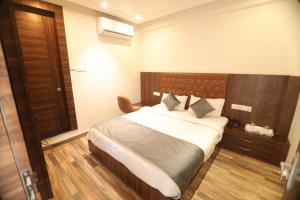 a bedroom with a large bed with a wooden headboard at Bless Inn in Prayagraj
