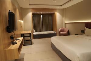a hotel room with a bed and a television at Sai Krishna Hill View Resort in Pawārkhera