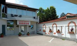 a building with a parking lot in front of it at Apartmani Medijana Niš in Niš