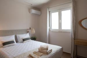 a bedroom with a bed with two towels on it at Lagonisi Olive Retreat in Kalívia Thorikoú +24 photos