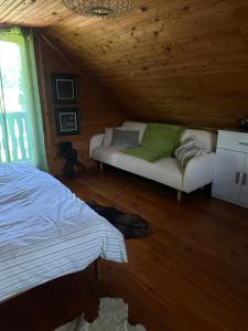 a bedroom with a bed and a couch in a cabin at Apartma Dobnik in Mozirje