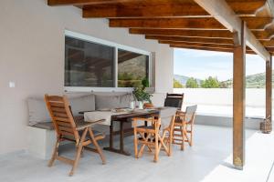 a dining room with a table and chairs at Lagonisi Olive Retreat in Kalívia Thorikoú