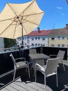 a table and chairs and an umbrella on a deck at FeWo Wagner in Fuggerstraße in Dillingen an der Donau