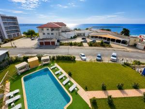 an overhead view of a swimming pool with chairs and the ocean at Hotel Venus in Venus