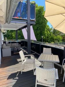 a deck with chairs and a table and an umbrella at FeWo Wagner in Fuggerstraße in Dillingen an der Donau