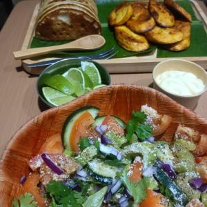 a plate of food with a salad on a table at Backpack Cabin A12892 in Oranjestad