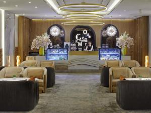 a lobby with a waiting room with tables and chairs at Novotel Ulaanbaatar in Ulaanbaatar