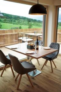 a dining room table with chairs and a large window at Chalet Auszeit im Schönseer Land in Schönsee