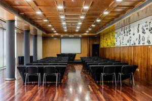 a conference room with black chairs and a white screen at Hotel Escuela Santa Cruz in Santa Cruz de Tenerife +55 photos