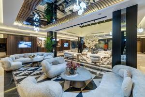 a lobby with couches and tables and a television at Batıhan Beach Resort & Spa in Kuşadası