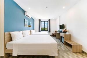 a bedroom with two beds and a couch and a television at Cat Ba Violet Hotel and Apartment in Cat Ba