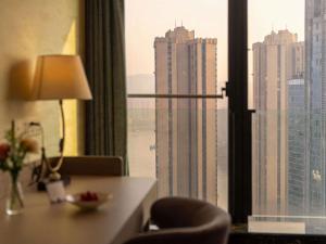 a hotel room with a desk and a view of a city at Mercure Chongqing Downtown in Chongqing