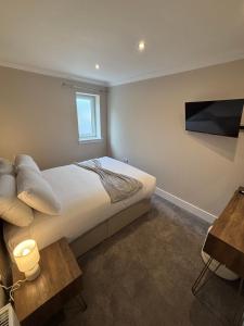 a bedroom with a bed and a tv on the wall at Raasay Apartment in Fort William