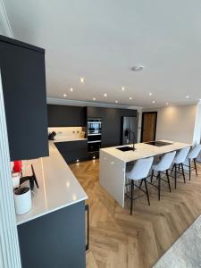 a kitchen with a white island and chairs in a room at Raasay Apartment in Fort William
