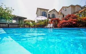 a large blue swimming pool in front of a house at Taean like the first time pension in Taean