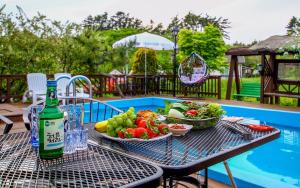 a table with two bowls of fruit and a bottle of wine at Taean like the first time pension in Taean