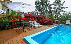 a pool with a table and chairs and an umbrella at Taean like the first time pension in Taean