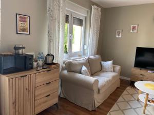 a living room with a couch and a television at Przy Jeziorze in Złotów