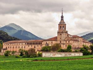 a large building with a clock tower and a mountain at Casa Alfredo in Badarán