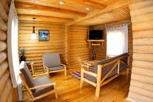 a room with two chairs and a television in a log cabin at Nebesa Hotel EZ in Chimgan