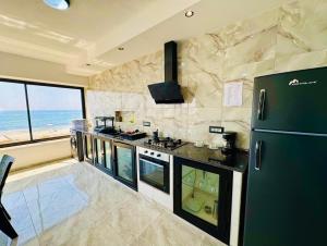 a large kitchen with a stove and a refrigerator at Casa del Mar Residences in Kelibia