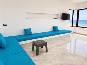a living room with blue couches and a table at Casa del Mar Residences in Kelibia