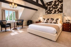a bedroom with a large bed and a table and chairs at The Mount Country Manor Hotel & Golf Wolverhampton in Wolverhampton +58 photos