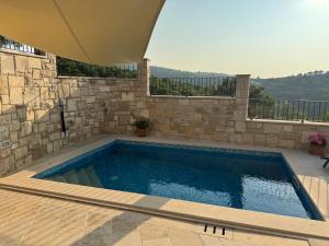 a swimming pool with a stone wall at Villa Mila in Splitska +67 photos