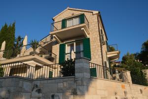 a house with a balcony on a wall at Villa Mila in Splitska