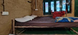 a bed in a room with two pillows on it at Heritage hut in Vashisht