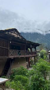 a building with a deck on a mountain at Heritage hut in Vashisht