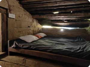 a bed in a room in a brick wall at Heritage hut in Vashisht +13 photos