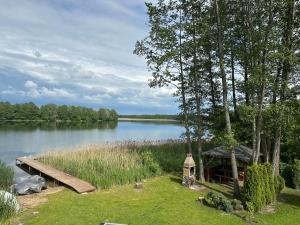 a cabin on the shore of a lake with a dock at Mazurski Chill House in Małkinie