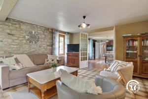 a living room with couches and a stone wall at 2 route de l'huître in Locoal-Mendon