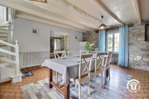 a dining room with a white table and chairs at 2 route de l'huître in Locoal-Mendon