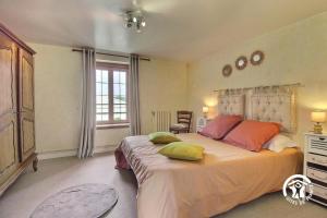 a bedroom with a large bed with pillows on it at 2 route de l'huître in Locoal-Mendon