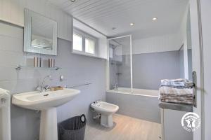 a white bathroom with a sink and a toilet at 2 route de l'huître in Locoal-Mendon +20 photos