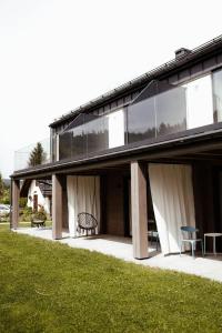a house with windows and a bench on a patio at Kozia Chata - apartamenty nad rzeką in Brenna +119 photos