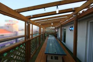 a wooden balcony with a blue bench on it at Boryeong Daecheon High Pension in Boryeong