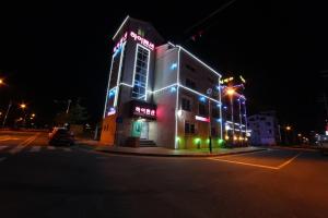 a building with neon lights on a street at night at Boryeong Daecheon High Pension in Boryeong