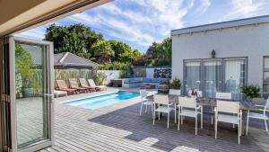 a patio with a table and chairs and a pool at Robin Retreat - Luxury 3 Bedroom Villa -Hermanus in Hermanus