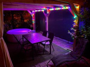 a table and chairs on a patio with lights at Sparkling Time Apartman in Hajdúszoboszló