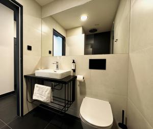 a bathroom with a white toilet and a sink at Factory Suites in Prague +16 photos