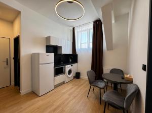 a small kitchen with a table and a refrigerator at Factory Suites in Prague