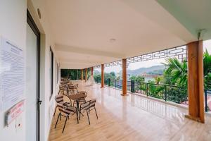 a room with chairs and tables on a balcony at Windy Homestay in Cat Ba