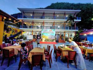 a group of people sitting at tables in a restaurant at Windy Homestay in Cat Ba